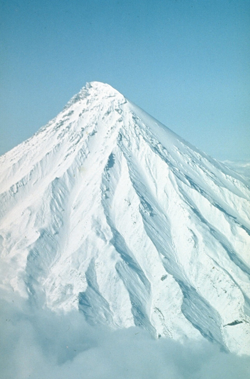 The flanks of Kronotsky contain radial erosional valleys up to 200 m deep. The summit, seen here from the north, consists of a basaltic-andesite lava extrusion. The conical, sharp-peaked volcano is one of the most distinctive in Kamchatka. Photo by Oleg Volynets (Institute of Volcanology, Petropavlovsk).