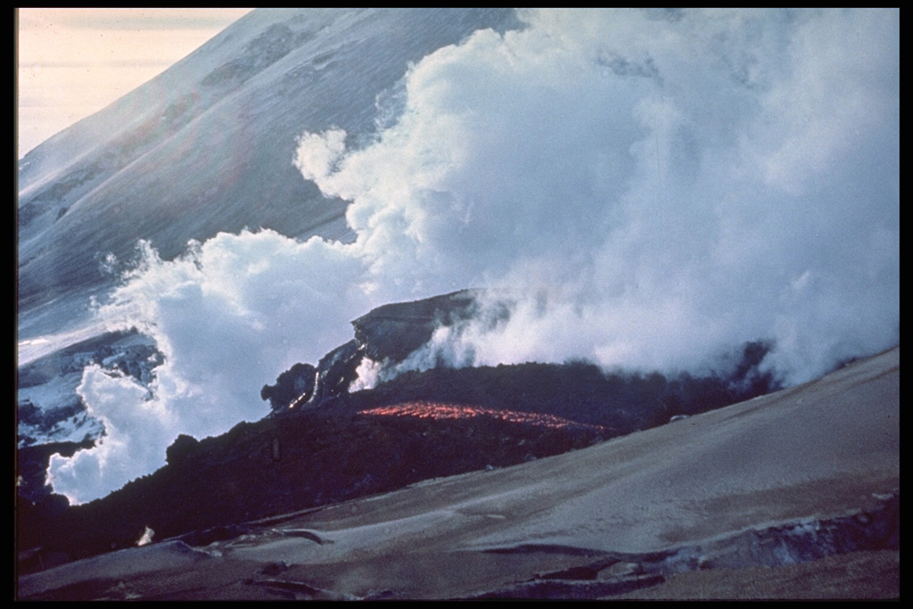 Steam rises from the margins of an active lava flow from a SW-flank vent of Klyuchevskoy in 1974. Renewed summit crater explosive activity began 8 April, with lava fountaining beginning 18 May. Increasing seismicity preceded the 23 August outbreak from 3,400-3,600 m elevation on the SW flank. Lava effusion continued until December.  Photo by I.T. Kirsanov, 1974 (courtesy of Oleg Volynets, Institute of Volcanology, Petropavlovsk).
