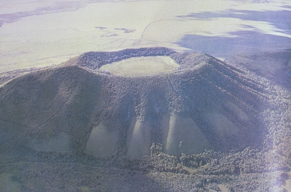 The Pleistocene Nangelaqiushan scoria cone contains a 500-m-wide flat-bottomed crater, is one of many cones forming the Wudalianchi volcanic field in Manchuria, NE China. The cones show a preferred alignment along three parallel NE-SW trends. The Wudalianchi volcanic field was named for five scenic lakes dammed by lava flows during a 1719-21 eruption, which formed two new scoria cones and produced a 65 km2 lava field. Photo courtesy of Jim Whitford-Stark, Sul Ross State University, Texas (published in Feng et al., 1979).