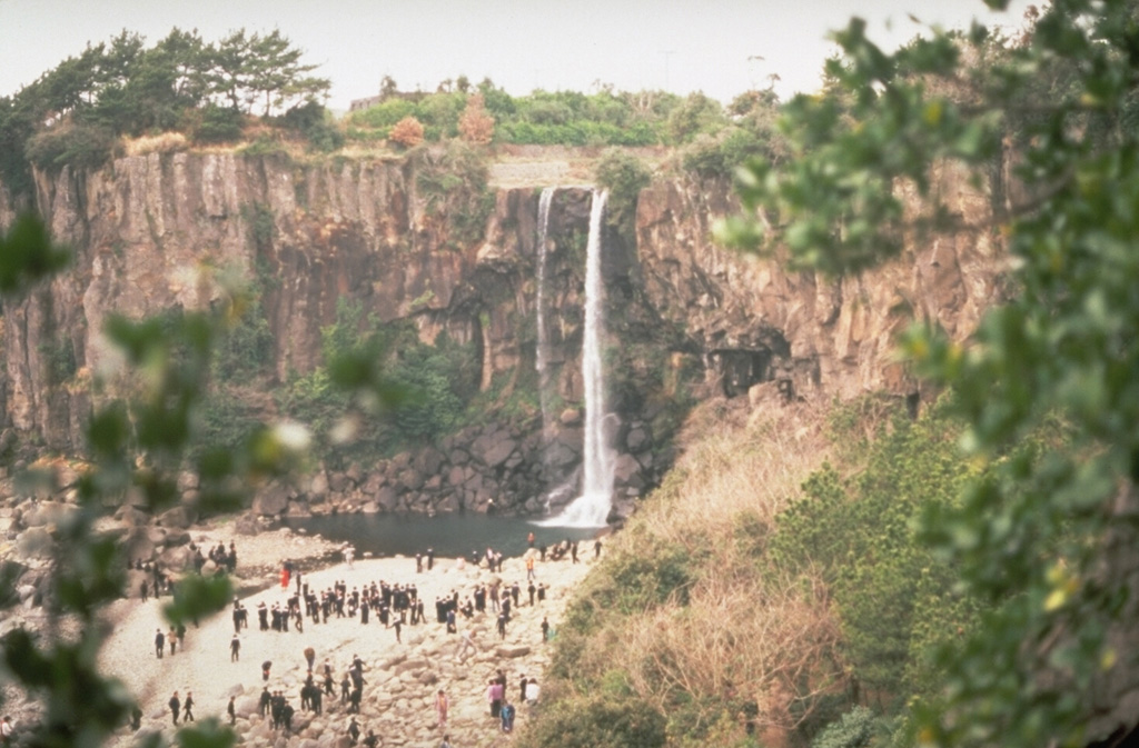 A waterfall plunging over a trachytic lava flow is a popular tourist destination on Cheju Island. An extensive lava plateau underlies the Halla shield volcano and extends to the coast of the 40 x 80 km island. The volcano dominates the center of the island and has been active from the Pleistocene until historical time. Photo by Norm Banks, 1980 (U.S. Geological Survey).