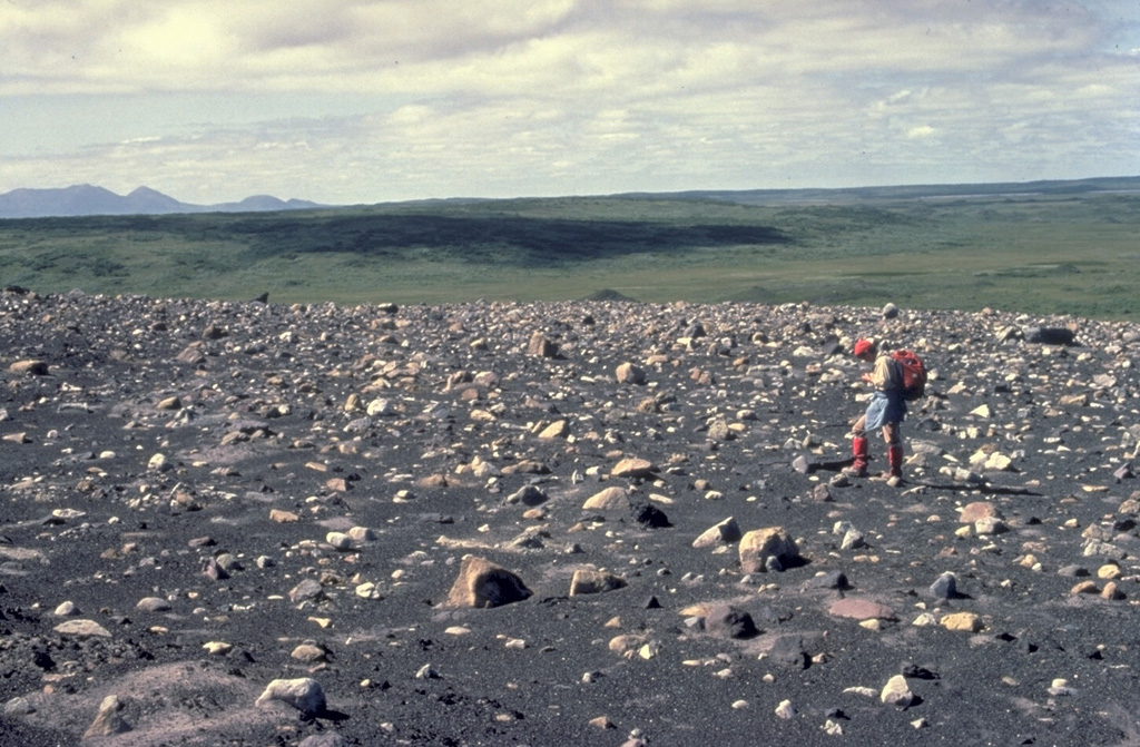 French volcanologist Katia Krafft observes blocky ejecta from the 1977 eruptions that formed Ukinrek Maars.  The 10-day-long eruption produced two new maars, 170-m-wide West Maar and 300-m-wide East Maar.  Phreatomagmatic explosions formed an ejecta blanket of ash and blocks that surrounded the new vents.   Copyrighted photo by Katia and Maurice Krafft, 1978.