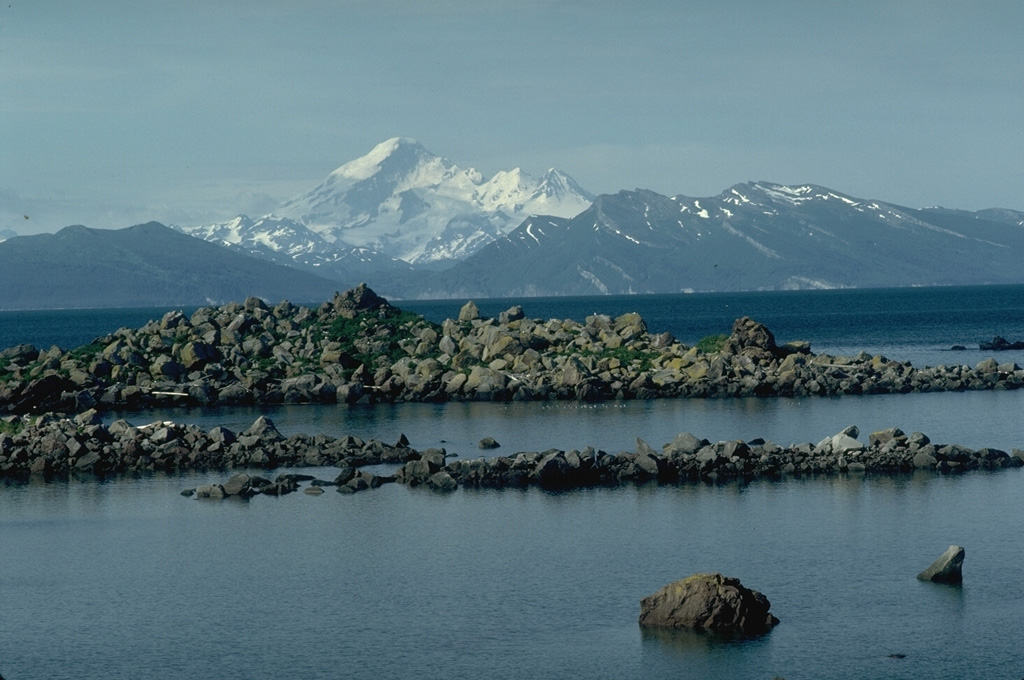 Iliamna rises across Kamishak Bay, 75 km N of Augustine Island. The features in the foreground are hummocks of a debris avalanche from the summit of Augustine in 1883 that reached the sea and extended the shoreline of the island by up to 2 km. Photo by Lee Siebert, 1987 (Smithsonian Institution).