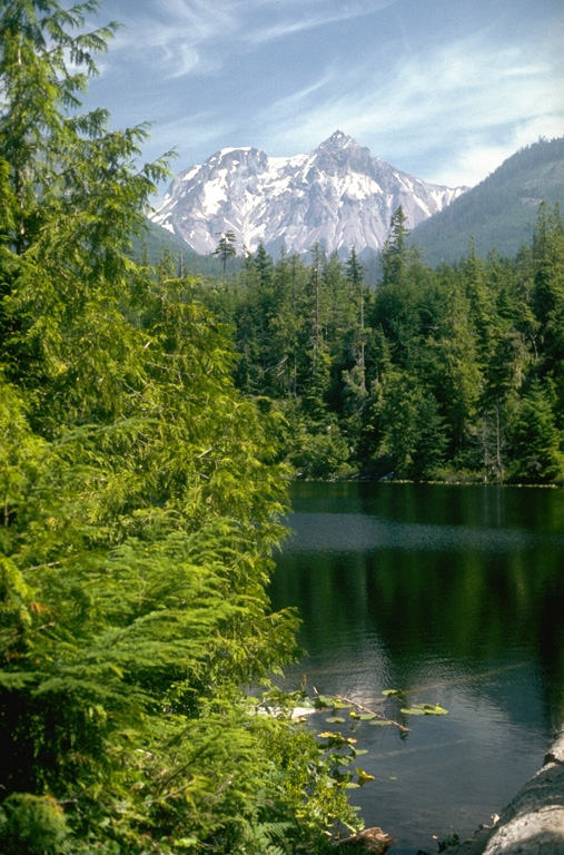 The Pleistocene Mount Garibaldi was partially constructed over the Cordilleran ice sheet. Its western face, seen from near Alice Lake, exposes the interior structure of the volcano and resulted from repeated landslides from the steep slope remaining from when the continental ice sheet retreated. The summit peak to the right is Atwell Peak and the rounded peak to the left is Dalton Dome, the source of some of Garibaldi's most recent eruptions. Photo by Lee Siebert, 1976 (Smithsonian Institution).