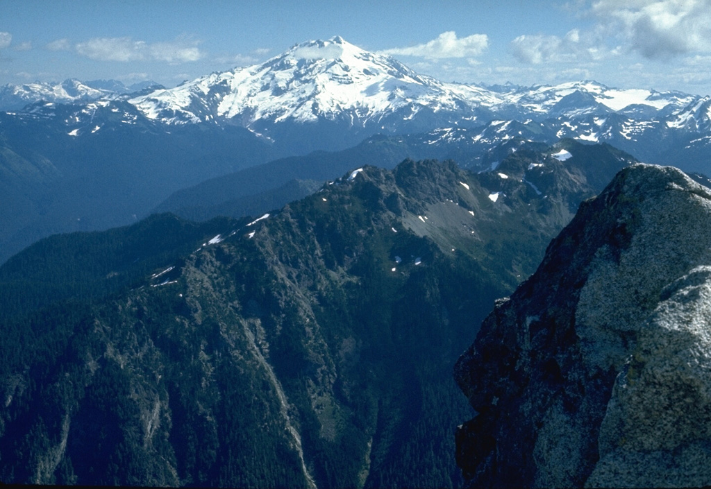 Glacier Peak, seen here from the summit of Mt. Pugh to the west, is located in the Glacier Peak Wilderness Area. It has produced voluminous eruptions that deposited thick pyroclastic flow and lahar deposits that blocked drainages, diverting the courses of the Suiattle and Swauk rivers northward into the Skagit River valley. Photo by Lee Siebert, 1972 (Smithsonian Institution).