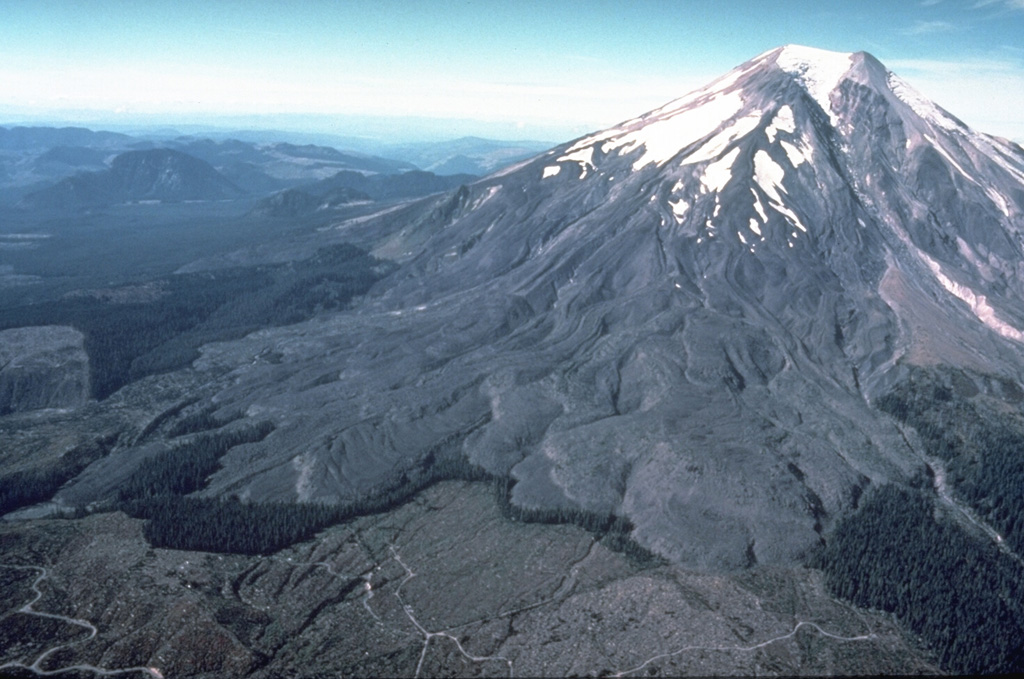Overlapping lava flows that erupted from summit vents during the first half of the 16th century are seen here on the SE flank of Mount St. Helens. During the same eruptive period lava flows also extended down the E and W flanks, and pyroclastic flows traveled down the N, W, S, and SE flanks. A thin line of standing trees separates the SE-flank lava flows from logging areas at the bottom of this 1978 photo. Photo by Rick Hoblitt, 1978 (U.S. Geological Survey).