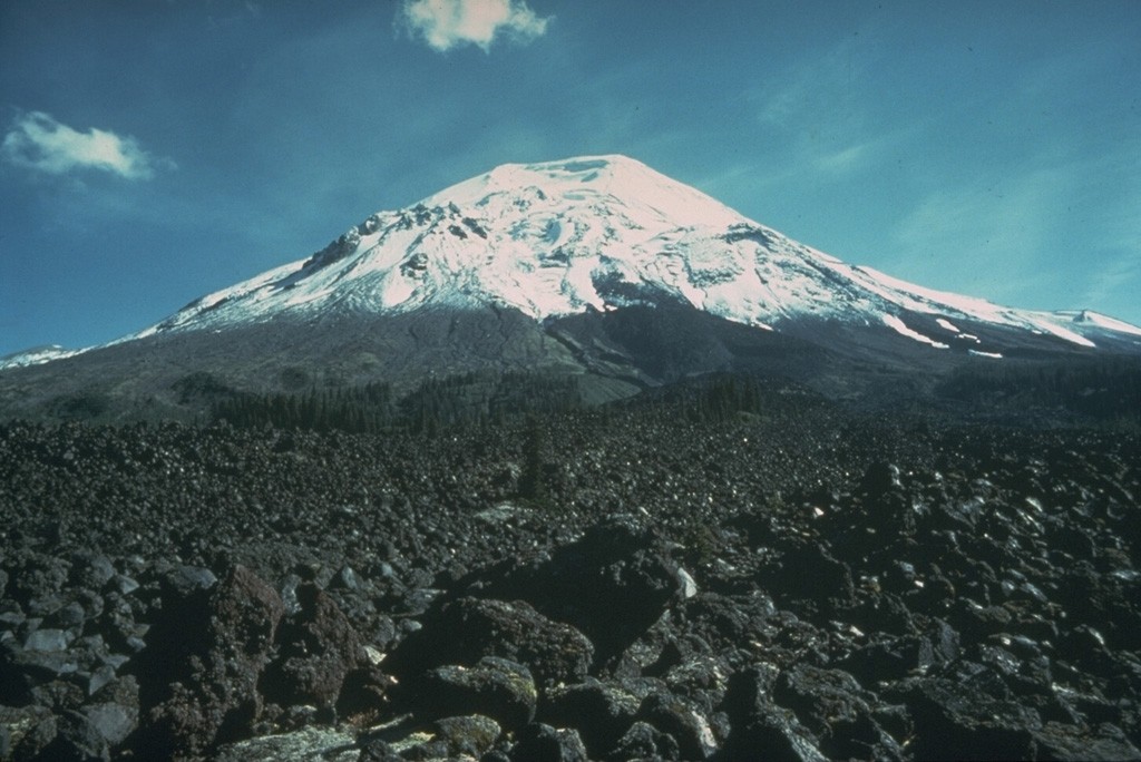 The Floating Island lava flow on the NNW flank of Mount St. Helens is in the foreground of this 1978 photo, before it was buried by the collapse in 1980. This lava flow has been dated using tree-ring evidence to an eruption in 1801, shortly after a major explosive eruption from a vent near the former Goat Rocks lava dome, halfway up the left-hand skyline in this photo. Photo by Rick Hoblitt, 1978 (U.S. Geological Survey).