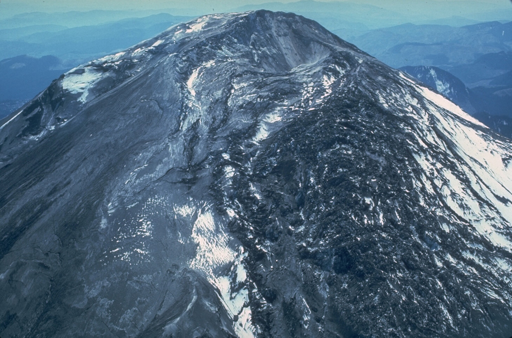 The highly fractured area on the right side of this 3 May 1980 photo is the renowned N-flank "bulge" of Mount St. Helens. Intense deformation producing northward displacements up to 2.5 m per day and reduction of rock strength by hydrothermal alteration caused the catastrophic collapse of the N flank, triggering the devastating magmatic explosive eruptions of 18 May. Photo by William Melson, 1980 (Smithsonian Institution).