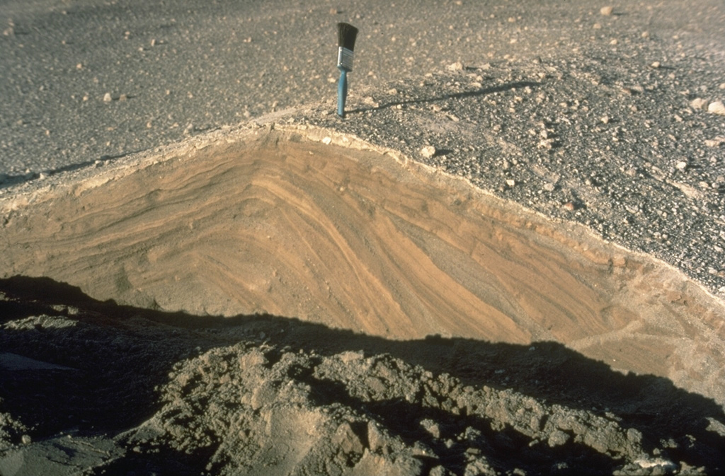 Pyroclastic surges are dilute pyroclastic flows with a high proportion of gas. They originated from secondary phreatic explosions at Mount St. Helens in 1980 and produced these cross-bedded layers. They were deposited from successive, rapidly moving horizontal clouds of gas, ash, and rock fragments that resulted from the interaction of hot pyroclastic flow deposits from the May 18 eruption with melt water produced by glacial ice carried down by the collapse of the summit. Photo by Norm Banks, 1980 (U.S. Geological Survey).