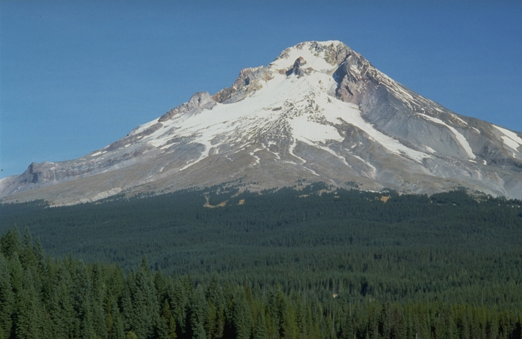 Trillium Lake provides a dramatic view of the broad debris fan on the S flank of Mount Hood that originated from growth of the Crater Rock lava dome, visible on the upper SW flank just below the summit. Dome growth and collapse produced block-and-ash flows and resulted in lahars down the Sandy River and White River drainages. Photo by Dave Wieprecht, 1993 (U.S. Geological Survey).