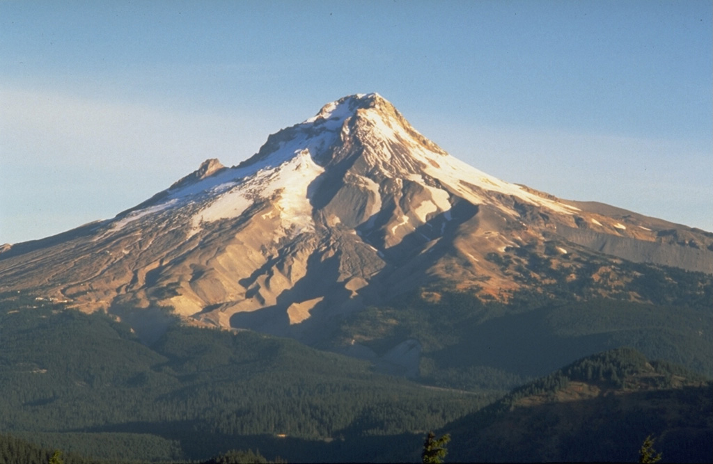 Mount Hood is seen here from Frog Butte on the SE side and shows the canyons of the White River drainage in the center. The smooth debris fan to its left formed during of growth and collapse of the Crater Rock lava dome just south of the summit. Illumination Rock forms the small peak midway up the left skyline. Photo by Dave Wieprecht, 1993 (U.S. Geological Survey).