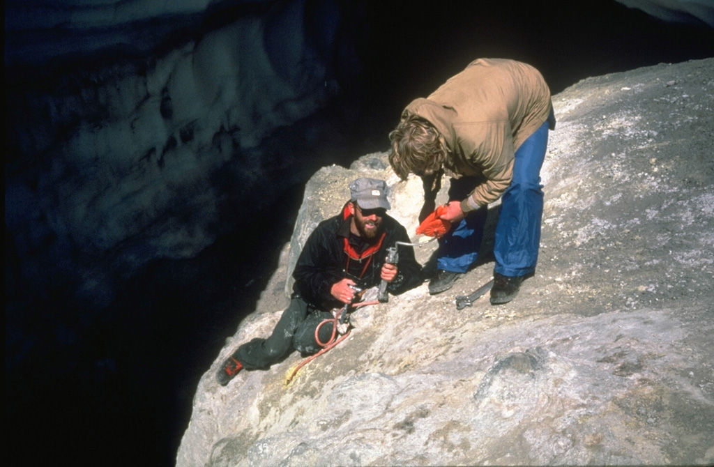 Scientists from the U.S. Geological Survey take gas samples at Devils Kitchen near the Crater Rock lava dome on the upper SW flank of Mount Hood. The Crater Rock area produces vigorous gas emission and results in extensive hydrothermal alteration of rock masses over broad areas. Photo by Bill Chadwick, 1982 (U.S. Geological Survey).