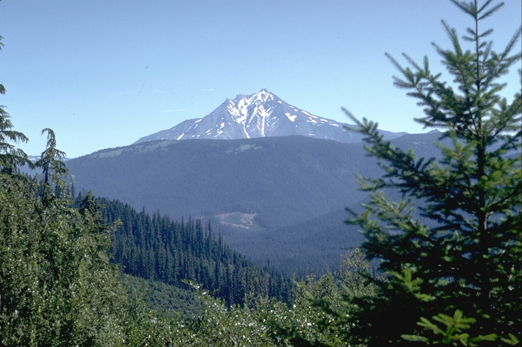 The western slopes of Mount Jefferson rise above forested hills composed of older Pleistocene volcanic rocks. Scoria cones younger than the eroded main edifice, which ceased activity during the late Pleistocene, are located to the south. Photo by Lee Siebert, 1982 (Smithsonian Institution).
