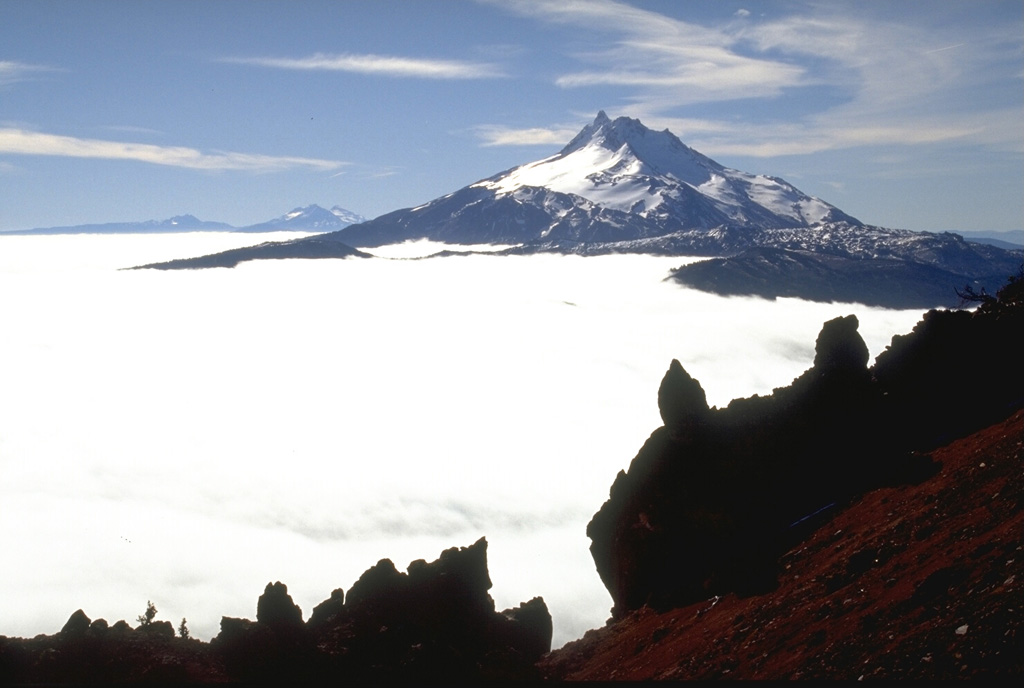 Mount Jefferson is seen to the south from Olallie Butte. The Three Sisters and Broken Top volcanoes are on the horizon to the left. Within 15 km from the main edifice domes and lava flows have erupted from at least 35 vents. Photo by Lee Siebert, 1995 (Smithsonian Institution).