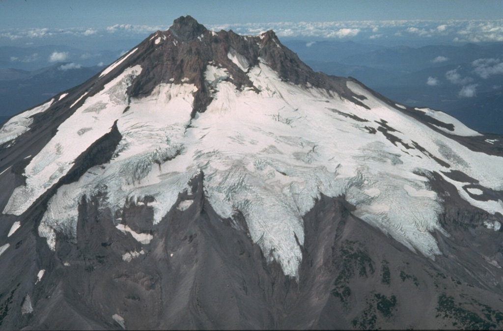 Volcanic activity at glacially eroded Mount Jefferson, Oregon's second highest peak, ended during the Pleistocene. However, scoria cones south of the volcano have been active as recently as about 1,000 years ago. The extensive Whitewater Glacier in the foreground has eroded deeply into the volcano across the E flank. Photo by Willie Scott, 1981 (U.S. Geological Survey).