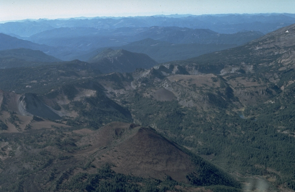 Forked Butte scoria cone in the foreground formed about 6,500 years ago south of Mount Jefferson, whose flank appears to the right. A lava flow from the southern base of Forked Butte traveled 8 km to the west down Cabot Creek. Photo by Dan Miller, 1977 (U.S. Geological Survey).