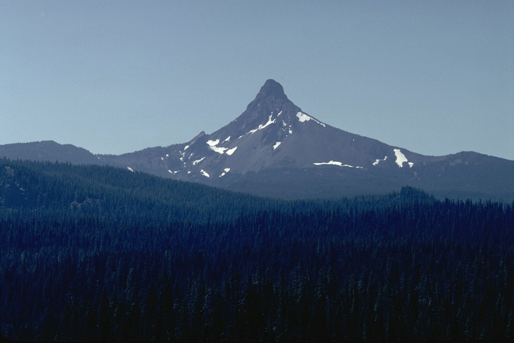The sharp-topped pinnacle of Mount Washington, seen here from east of Santiam Pass on its NE, is a lava plug that caps a heavily eroded shield volcano.   The steep-sided lava plug forming the summit was the last major Oregon peak to be climbed, resisting ascent until 1923. Photo by Lee Siebert, 1982 (Smithsonian Institution).