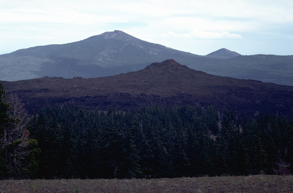 Little Belknap shield volcano, seen here from the side of Belknap on the west with Black Crater in the background, formed about 2,900 years ago. Lava flows from Little Belknap, buttressed against the higher Belknap volcano on the west, spread primarily to the east. Photo by Lee Siebert, 1982 (Smithsonian Institution).