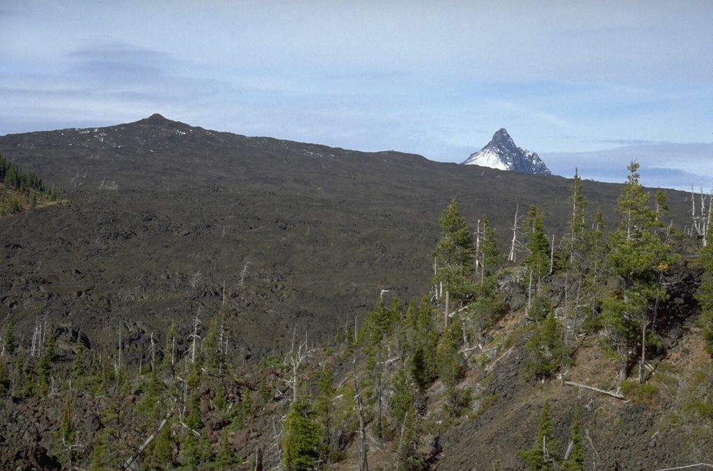 Little Belknap (upper left) is an example of a small shield volcano in a continental margin setting. Little Belknap was constructed on the E flank of Belknap volcano and erupted lava flows over the McKenzie Pass area of the central Oregon Cascades about 2,900 years ago. Collapsed lava tubes that fed the flows diverge radially away from the summit. The summit of Mount Washington appears above the horizon to the right. Photo by Lee Siebert, 1995 (Smithsonian Institution).