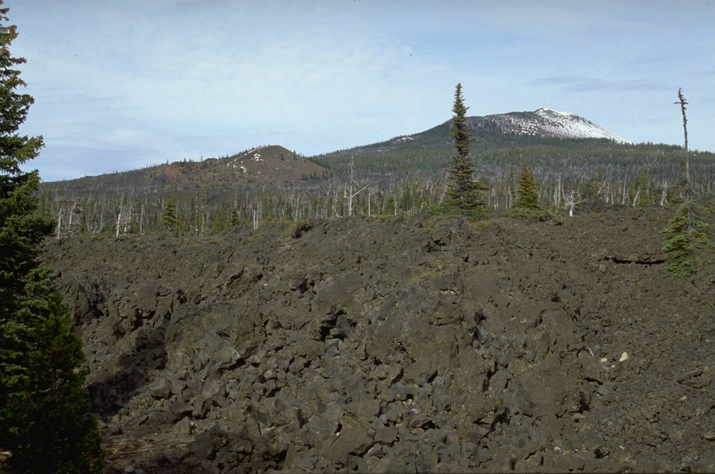 The South Belknap scoria cone on the left skyline was constructed on the SW flank of Belknap shield volcano (upper right) about 2,600 years ago during an eruption that produced lava flows towards the south. The foreground lava flows originated from Belknap. Photo by Lee Siebert, 1995 (Smithsonian Institution).