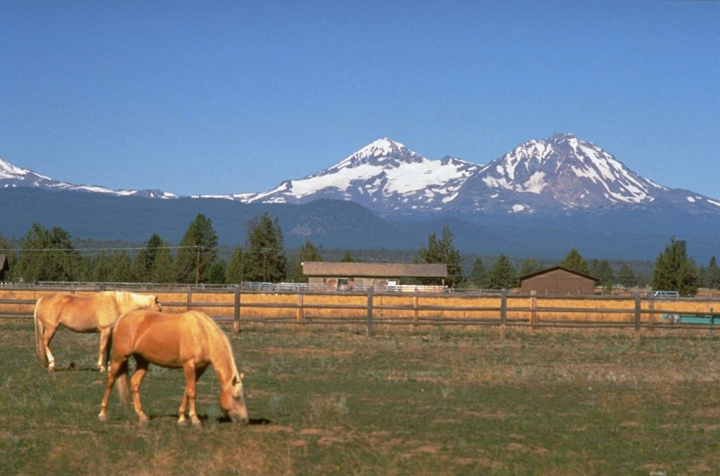 North Sister volcano on the right and Middle Sister to its left rise above ranch lands of eastern Oregon. These large volcanoes have not been active since the Pleistocene, but scoria cones on the north flank of North Sister have produced some of the youngest lava flows in the Cascade Range. Photo by Dave Wieprecht, 1995 (U.S. Geological Survey).