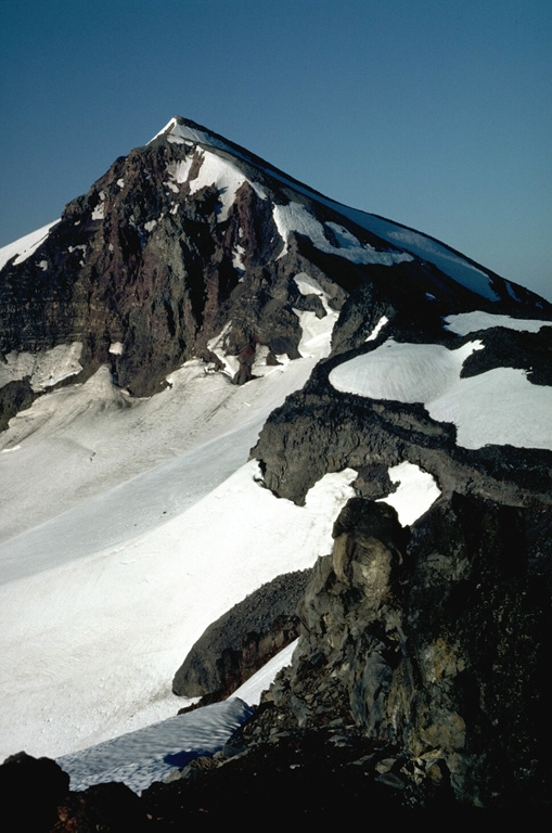 Middle Sister, seen here from the NE near the saddle between North Sister and Middle Sister, is younger than North Sister. The steep cliffs forming the eastern flank are due to glacial erosion that exposed part of its dacite plug. Photo by Lee Siebert, 1984 (Smithsonian Institution).