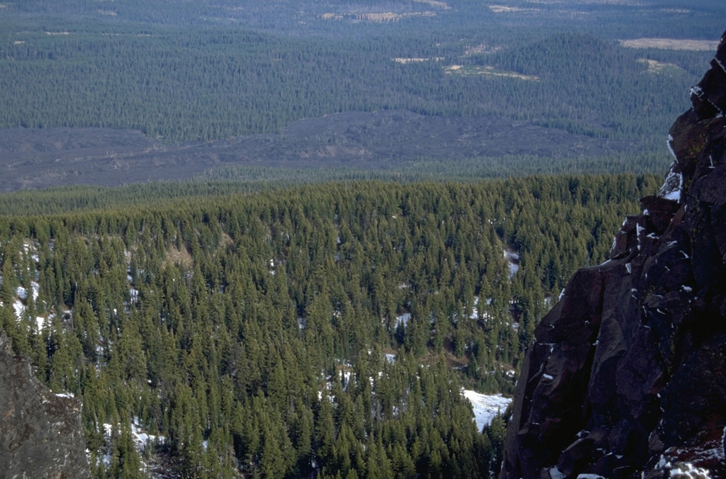 The lava flow across the upper part of the photo, seen here from Black Crater, originated from Yapoah cone on the north flank of North Sister about 2,600-2,900 years ago. The flow traveled 5 km N before being diverted by lavas from Little Belknap shield volcano and flowing an additional 8 km NE. Photo by Lee Siebert, 1995 (Smithsonian Institution).