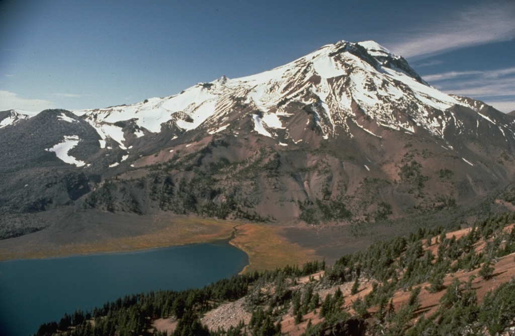 South Sister is the highest of the Three Sisters volcanoes and is seen here above Green Lake from the west flank of Broken Top volcano. The bare slope to the far-left is the Newberry lava flow, the northernmost of a series of SE-flank obsidian domes and flows. Photo by Lyn Topinka, 1985 (U.S. Geological Survey).