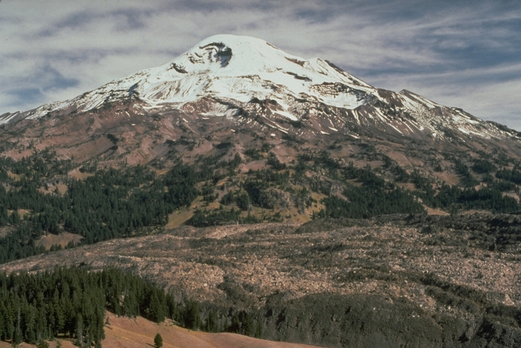 The Rock Mesa lava flow in the foreground erupted from a vent on the SW flank of South Sister volcano about 2,300 years ago. Emplacement of the lava flow was the final stage of an eruption that began with strong explosions accompanied by pyroclastic flows and surges. Photo by Lyn Topinka, 1985 (U.S. Geological Survey).