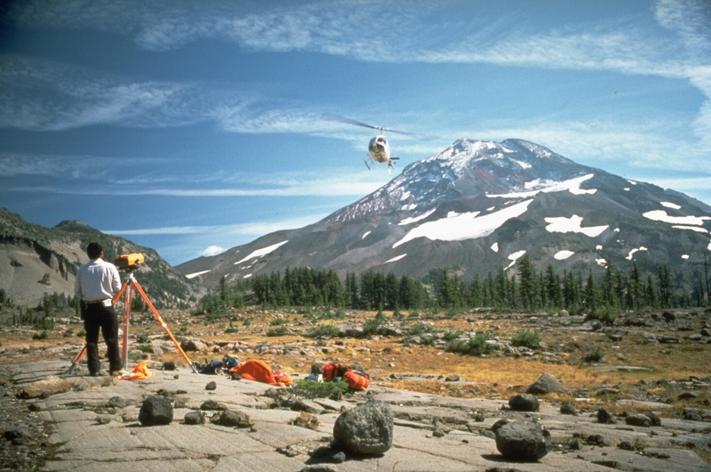 A helicopter delivers supplies to a U.S. Geological Survey field crew conducting Electronic Distance Measurement surveys on the flank of South Sister volcano in the central Cascades of Oregon. Photo by Lyn Topinka, 1986 (U.S. Geological Survey).