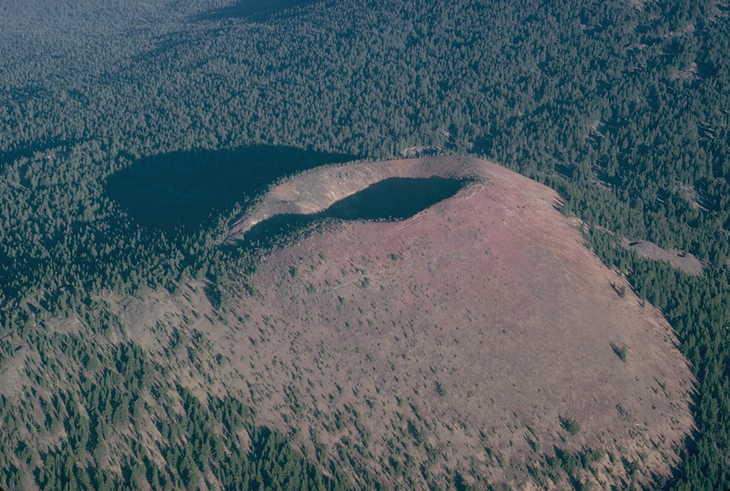 Kwohl Butte is one in a 25-km-long chain of scoria cones and small shield volcanoes south of Mount Bachelor in the central Cascade Range of Oregon. Despite the youthful appearance of the cone, geologic mapping indicates construction of the chain was completed about 12,000 years ago. Photo by Lee Siebert, 1981 (Smithsonian Institution).