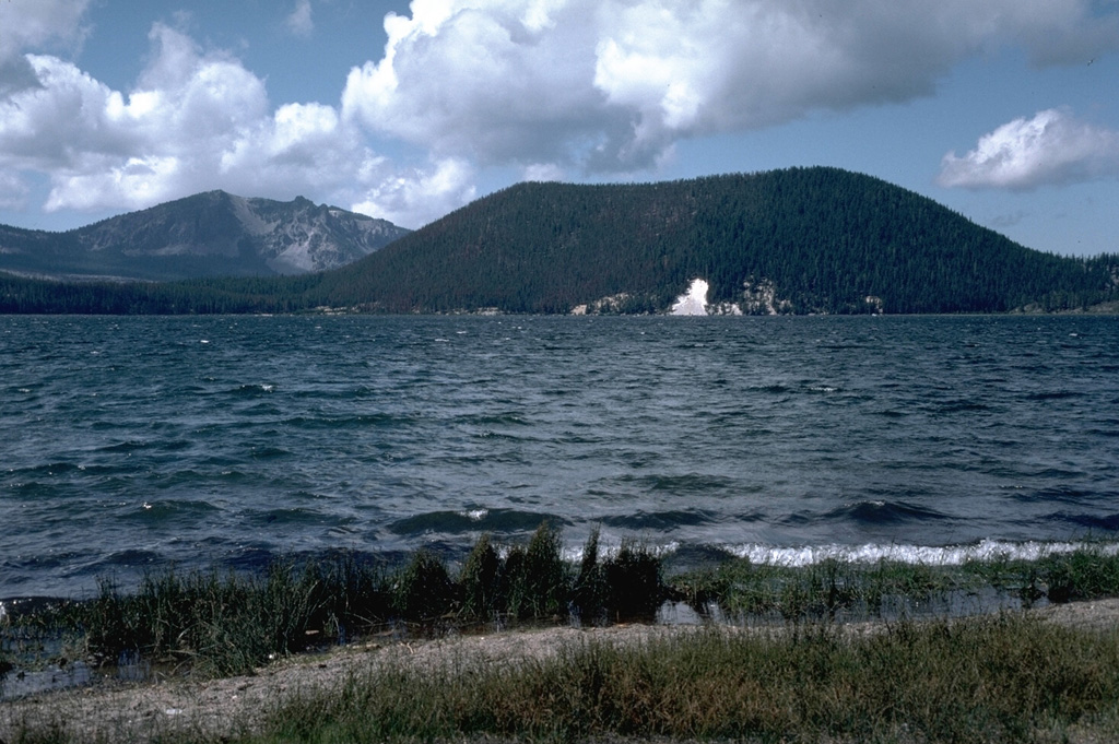 The Central Pumice Cone at the right formed during a major rhyolitic eruption about 6,400 years ago. Many other vents on the north and south caldera walls and the caldera floor were also active at this time, producing pumice rings and obsidian flows. Paulina Peak forms the high point on the south caldera rim at the left. Photo by Lee Siebert, 1984 (Smithsonian Institution).