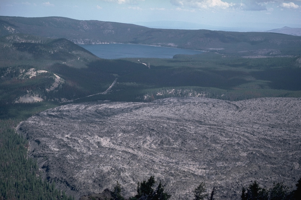 The Big Obsidian Flow lava flow in the foreground covers about 2.6 km2 of the floor of Newberry caldera and was emplaced about 1,300 years ago. The eruption occurred at a vent at the base of the southern caldera wall, out of view to the right. Photo by Lee Siebert, 1984 (Smithsonian Institution).