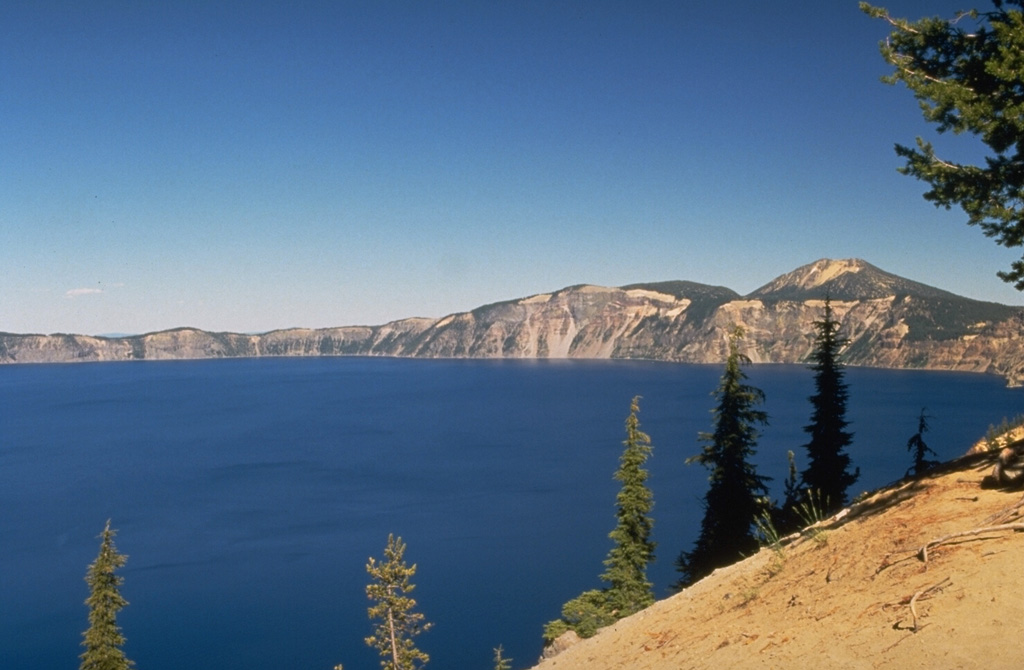 The 8 x 10 km wide Crater Lake caldera was formed about 7,700 years ago when Mount Mazama, a complex of overlapping stratovolcanoes, collapsed following a major explosive eruption. The eruption produced widespread ashfall and pyroclastic flows that traveled as far as 70 km. The caldera, seen here from the S rim, is 1,200 m deep and filled to half its depth by Crater Lake. Photo by Dave Wieprecht, 1995 (U.S. Geological Survey).