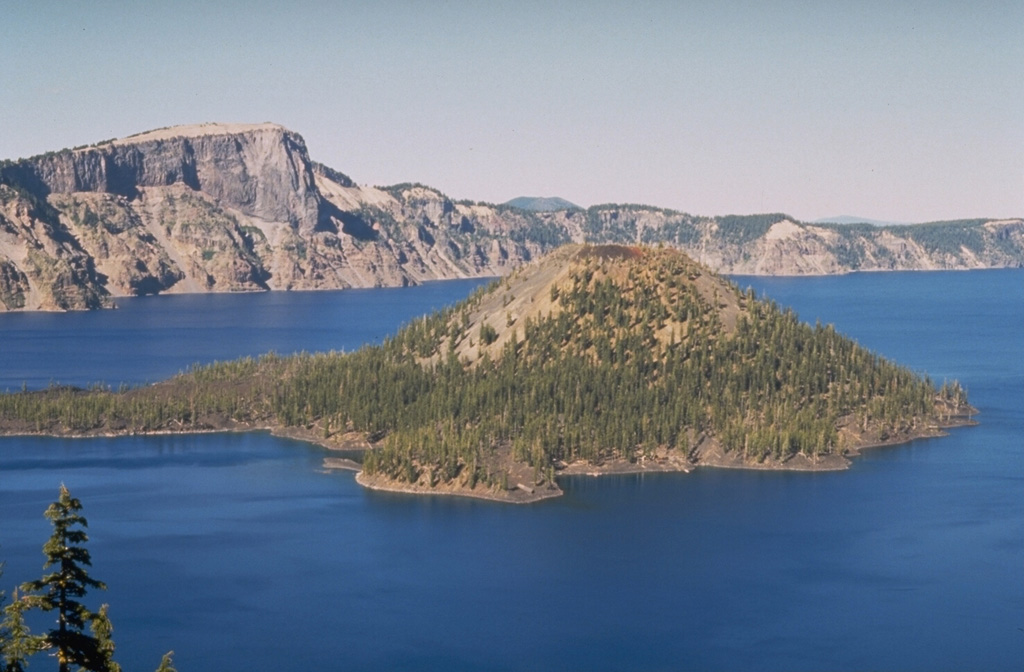 Wizard Island is a scoria cone in Crater Lake caldera, which formed about 7,700 years ago. A lava flow from a vent on its NW flank forms the peninsula to the left. Llao Rock, a massive lava flow that forms the peak on the caldera rim, was erupted about 100-200 years prior to formation of Crater Lake caldera. Photo by Dave Wieprecht, 1995 (U.S. Geological Survey).