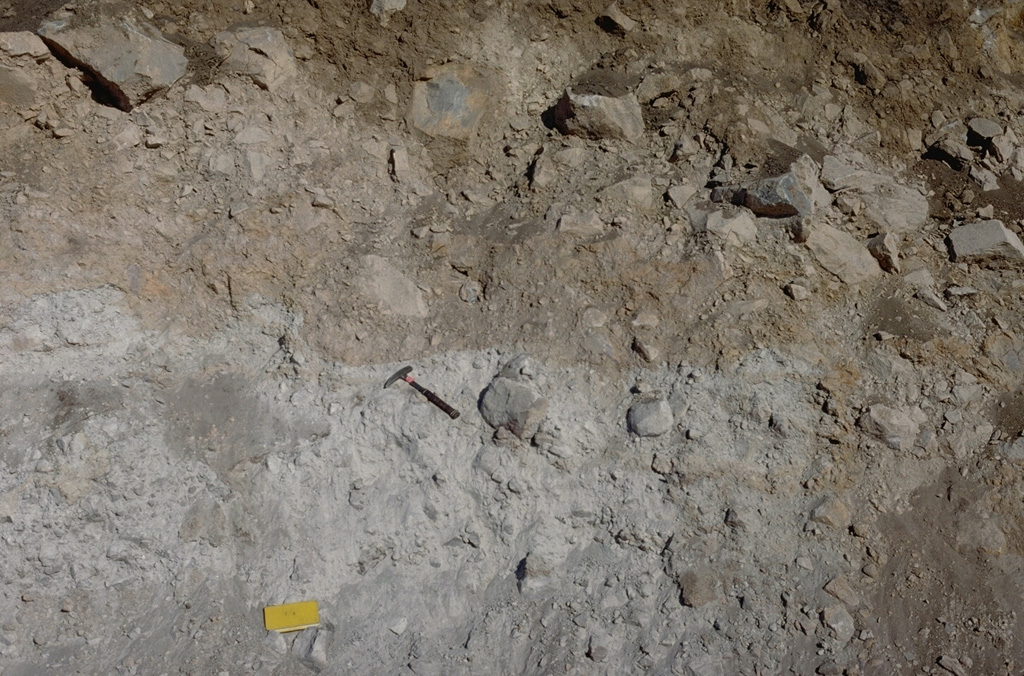 A roadcut exposes the internal structure of the debris avalanche deposit that formed during collapse of Mount Shasta during the Pleistocene. This deposit contains large angular sections composed of rock and crushed matrix of similar material (like the light-gray area in this photo), in direct contact with other lithologies (brown) from other areas of the pre-collapse volcano. This is due to different sections mixing as the debris avalanche traveled across the landscape. Photo by Lee Siebert, 1981 (Smithsonian Institution).