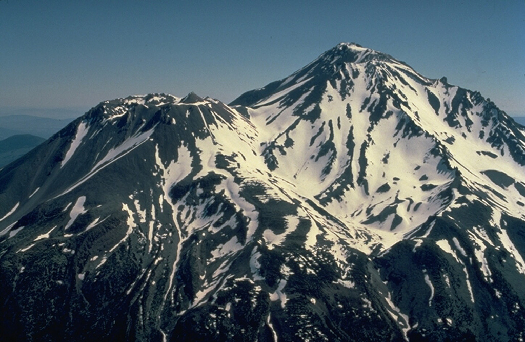 Mount Shasta in northern California, the largest volcano of the Cascade Range, is a complex stratovolcano composed of at least four overlapping volcanoes.  From the SW, Shasta's prominent west flank lava dome, Shastina, appears at the left.  Both it and the summit Hotlum cone were formed during the Holocene.  The only historical eruption of Shasta occurred in 1786 and was observed from off the coast of California by the French explorer La Perouse. Copyrighted photo by Katia and Maurice Krafft, 1989.