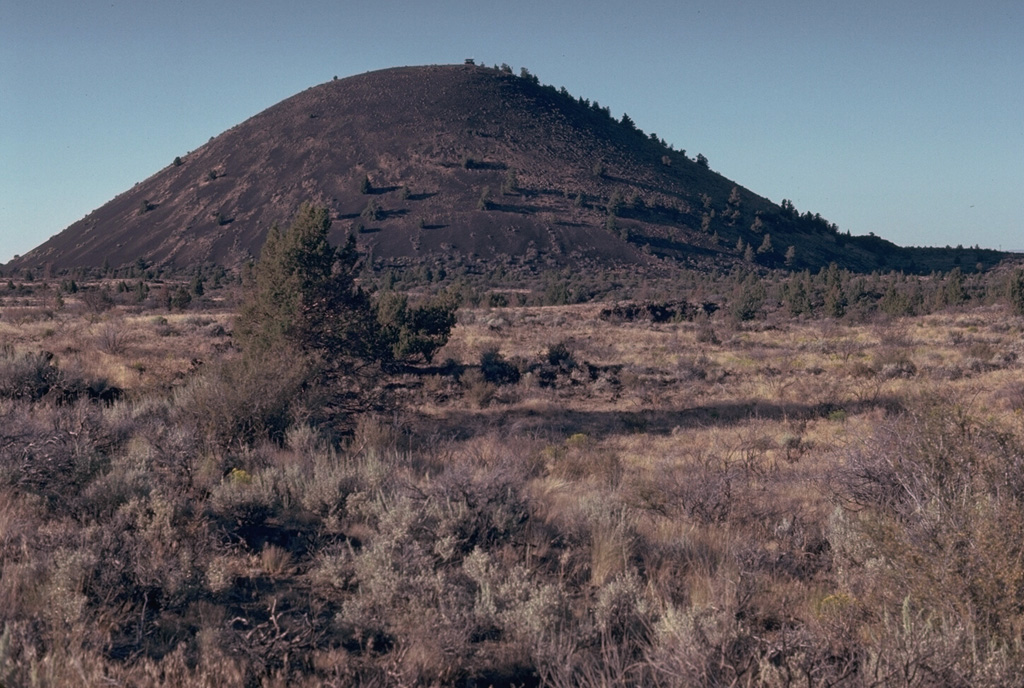 Schonchin Butte, a late-Pleistocene scoria cone on the north flank of Medicine Lake volcano, is one of the prominent landmarks of Lava Beds National Monument. A large number of lava tubes in the area fed late-Pleistocene and Holocene lava flows. Photo by Lee Siebert, 1981 (Smithsonian Institution).