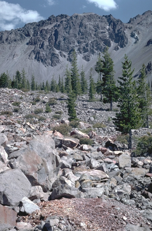 The blocky surface of Chaos Jumbles in the foreground was produced by collapse of a portion of the Chaos Crags lava dome complex in the background about 1650 CE.  The cold rock avalanche traveled 5 km from its source, and may have occurred in the absence of any eruptive activity.  Three successive lobes of the avalanche cover an area of 8 km2. Photo by Lee Siebert, 1982 (Smithsonian Institution).