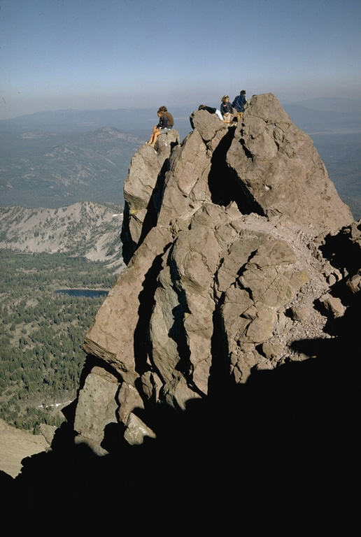 Hikers perch on a small pinnacle of dacitic lava that forms the high point of Lassen Peak, the southernmost major volcano in the Cascade Range that stretches from southern British Columbia to northern California.  Lassen Peak is a large dacitic lava dome that last erupted from 1914 to 1917. Photo by Lee Siebert, 1968 (Smithsonian Institution).