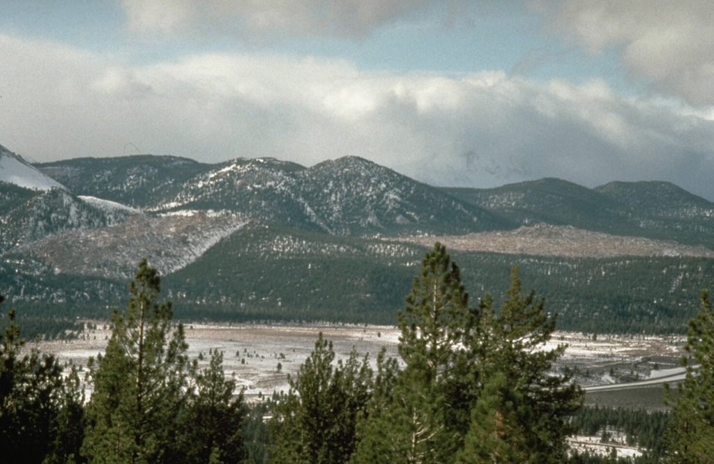 The unvegetated Glass Creek lava flow on the left and Obsidian Flow on the right are among a group of obsidian lava flows and domes that were emplaced during a major eruption from the Inyo Craters about 600 years ago.  The eruption, originating from a shallow dike, began with powerful explosive activity, pyroclastic flows, and a series of phreatic explosions, and ended with effusion of the lava domes and flows. Photo by Larry Mastin, 1991 (U.S. Geological Survey).