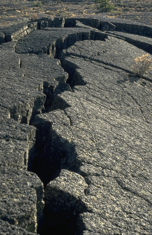 Pressure ridges, formed when moving, still-fluid magma buckled the solidified surfaces of pahoehoe lava flows, are one of the many lava flow features easily observed at Craters of the Moon National Monument in Idaho. Photo by Lee Siebert, 1994 (Smithsonian Institution).