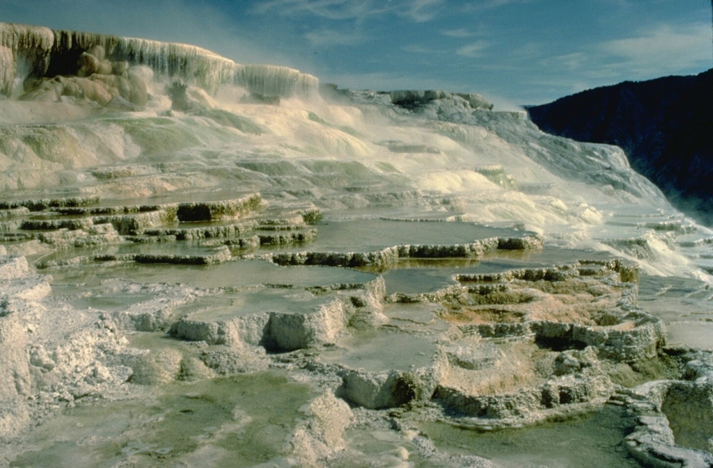 The dramatic travertine terraces of Mammoth Hot Springs in NW Yellowstone are formed by redeposition of dissolved limestone rock underlying the Mammoth area that is carried in solution in hot spring waters.  Changes in hot spring passageways can produce very rapid changes in terrace morphology. Copyrighted photo by Katia and Maurice Krafft, 1984.