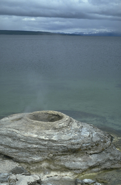 The West Thumb Geyser Basin at the SW end of Yellowstone Lake contains thermal features, such as this sinter mound, both above and below the lake shore.  The West Thumb embayment of Yellowstone Lake is a smaller caldera that formed as a result of an explosive eruption during a period of mainly lava-producing eruptions during the past 150,000 years. Photo by Lee Siebert, 1994 (Smithsonian Institution).