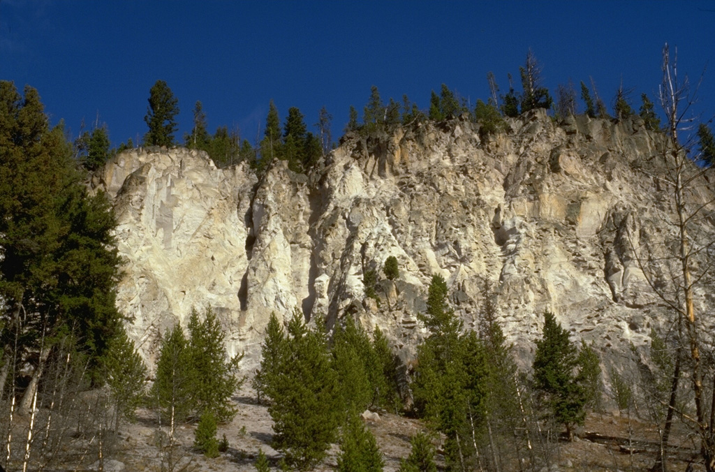 The thick cliffs are composed of massive ash-flow deposits of the Lava Creek Tuff, erupted about 640,000 years ago.  Eruption of the 1000 cu km Lava Creek Tuff resulted in the formation of the present 45 x 85 km wide caldera, the latest of three large calderas formed at Yellowstone during the past 2 million years. Photo by Lee Siebert, 1994 (Smithsonian Institution).