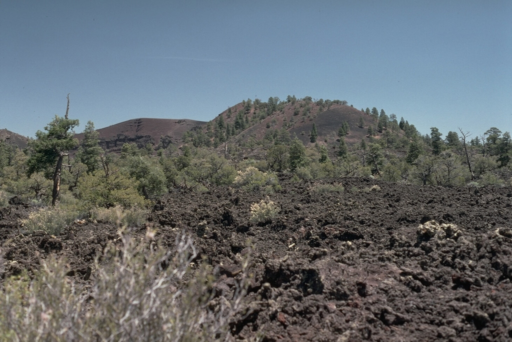 Bandera Crater, one of the youngest features of the Zuni-Bandera lava field, is a breached cinder cone that fed a lava flow dated about 9000 BCE.  The Bandera lava flow forms part of El Malpais (Spanish for "badlands"), the largely unvegetated, youngest Quaternary basaltic lava flows that cover a broad area south of Grants, New Mexico. Photo by Lee Siebert, 1987 (Smithsonian Institution).