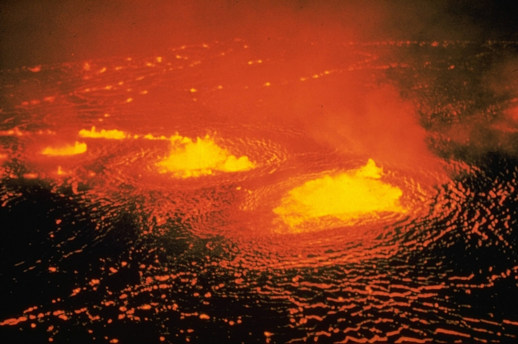 Low lava fountains rise above an active lava lake in Halema‘uma‘u crater on 31 May 1954, near the beginning of a three-day eruption. About a half hour after the start of the eruption lava flows effused from a fissure that opened across the floor of the Kilauea caldera, ENE of Halema‘uma‘u. Photo by Jerry Eaton, 1954 (U.S. Geological Survey).