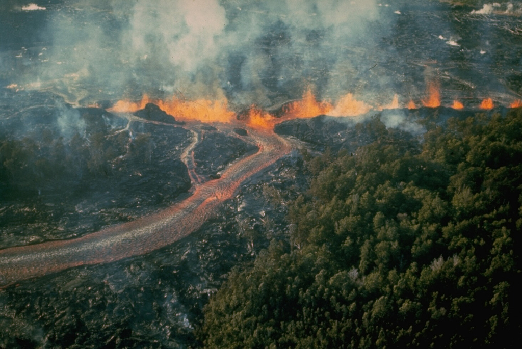 Lava fountains along an October 1968 East Rift Zone fissure at Kilauea produced the lava flow in the foreground. Starting on 7 October a series of fissures extended from the E flank of Kane Nui o Hamo to 3.5 km E of Nāpau Crater. The eruption continued until the 21st, covering much of the March 1965 lava flows and again produced lava cascades into Nāpau Crater. Photo by U.S. Geological Survey, 1968.