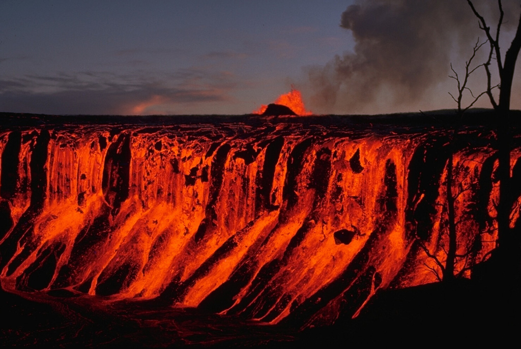 Lava flows from fountains at the Mauna Ulu cone in the background cascade down the Aloi crater walls on 30 December 1969. The 1969-74 Mauna Ulu eruption eventually filled both Aloi crater west of Mauna Ulu, and Alae crater to the east. Photo by Don Swanson, 1969 (U.S. Geological Survey).