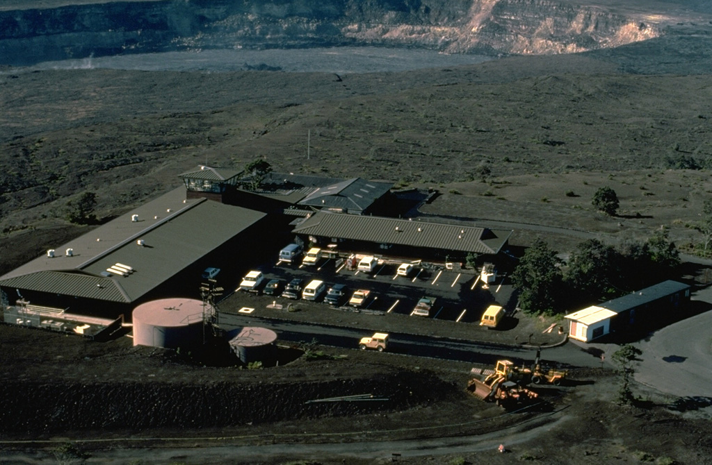 The Hawaiian Volcano Observatory sits on the rim of Kilauea caldera.  Staff scientists are responsible for monitoring the volcanoes on the island of Hawaii and Maui's active volcano, Haleakala.  Volcanologists also conduct an active research and field mapping program to determine the geologic history of individual volcanoes.  Halemaumau pit crater, at the top of the photo, was the site of long-term lava lake activity that continued at Kilauea for a century prior to 1924.  Brief, intermittent eruptions at Halemaumau have occurred since then, most recently in 1975. Copyrighted photo by Katia and Maurice Krafft, 1984.