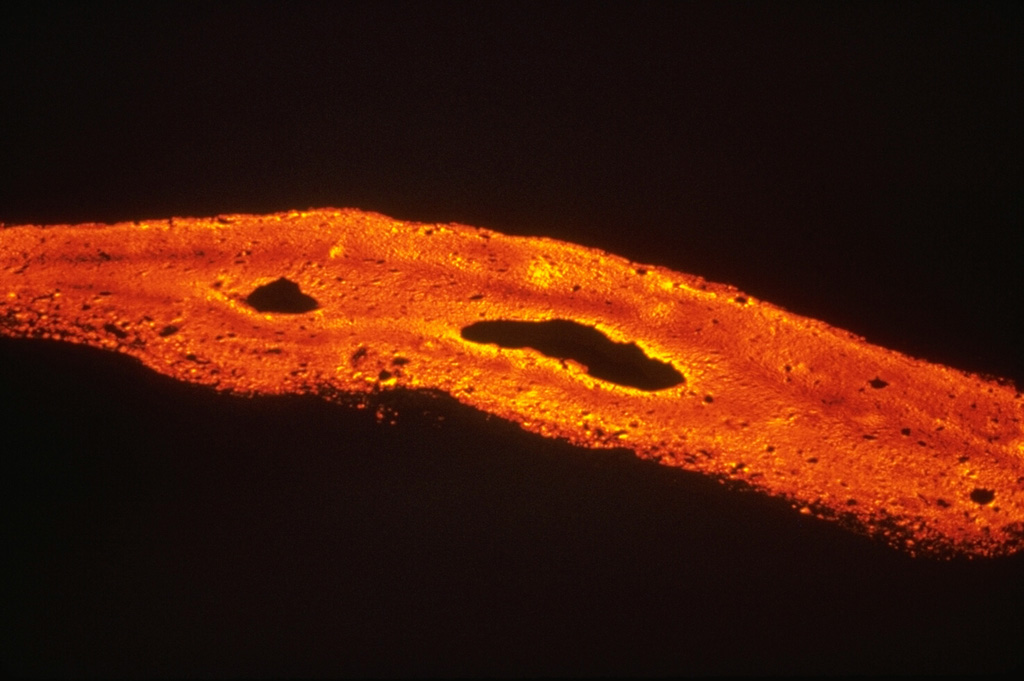 Lava flows are produced when magma reaches the surface and is erupted non-explosively. Basaltic lava flows, such as this September 1979 flow from the East Rift Zone of Kilauea volcano, are Earth's most common volcanic product. Basaltic lava flows typically have initial temperatures of 1,000-1,250°C with a range of flow velocities.  Photo by Richard Moore, 1977 (U.S. Geological Survey).